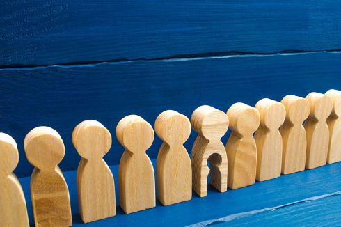 © Andrii Yalanskyi - stock.adobe.com Foto: Holzfiguren in einer Reihe, eine hat ein ausgeschnittenes Kind